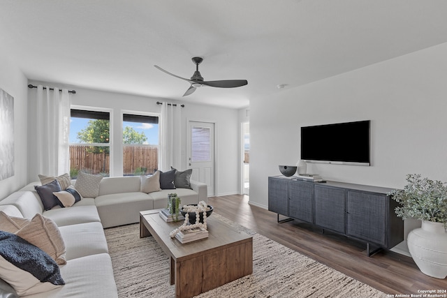 living room with ceiling fan and dark wood-type flooring