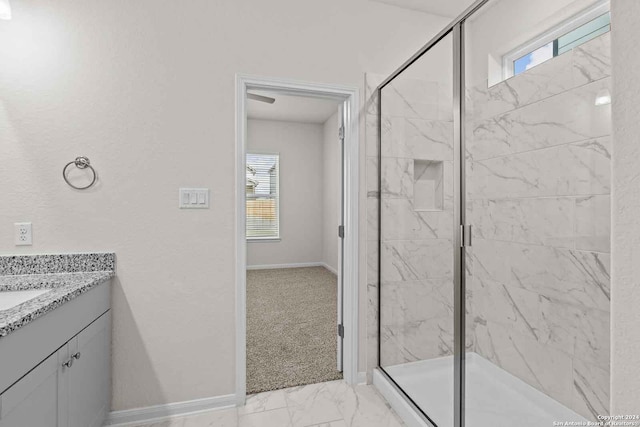 bathroom with vanity, a shower with door, and a wealth of natural light