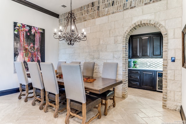 dining room featuring wine cooler, crown molding, and a notable chandelier