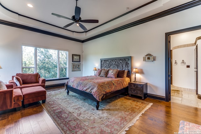 bedroom with hardwood / wood-style flooring, ceiling fan, and ornamental molding