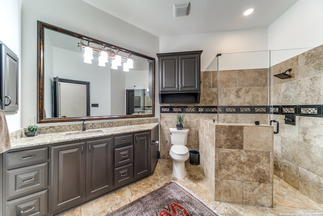 bathroom featuring toilet, vanity, tile walls, and walk in shower