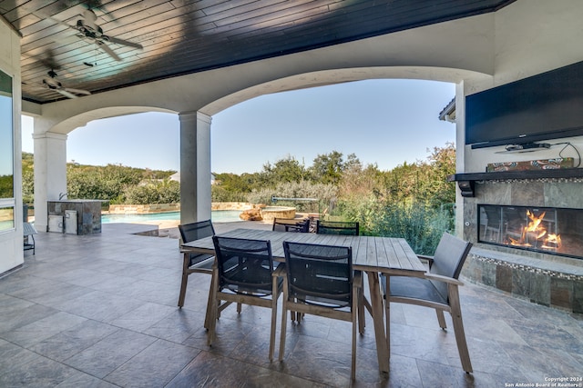 view of patio featuring ceiling fan and an outdoor fireplace