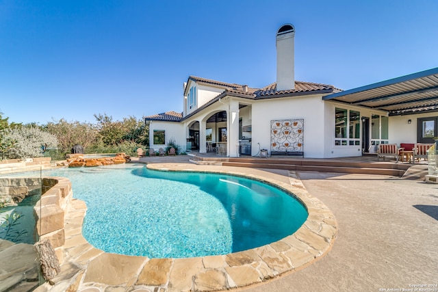 view of pool with a patio and pool water feature