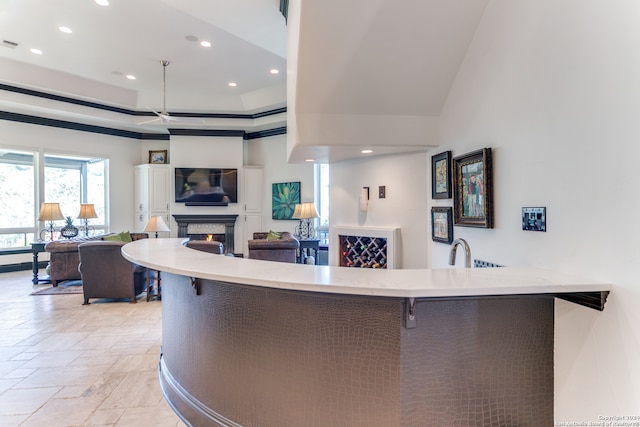 kitchen featuring a breakfast bar area, kitchen peninsula, sink, and a high ceiling