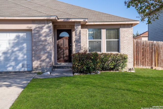 entrance to property featuring a garage and a yard