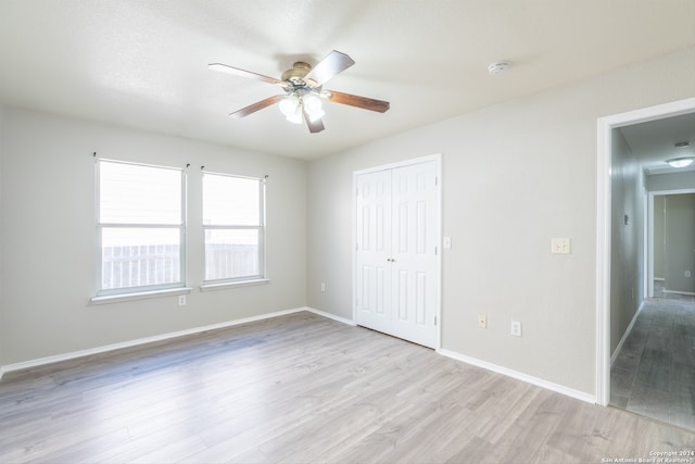 unfurnished bedroom with a closet, light hardwood / wood-style flooring, and ceiling fan