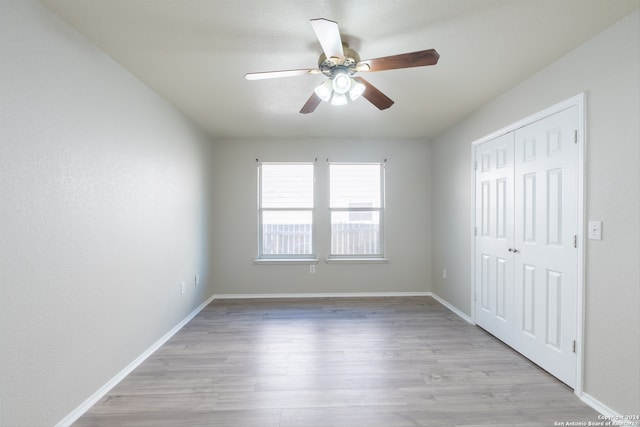 unfurnished bedroom with ceiling fan and light hardwood / wood-style flooring