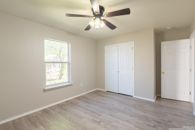 unfurnished bedroom with light wood-type flooring, a closet, and ceiling fan