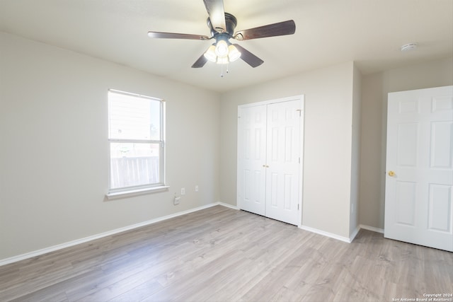 unfurnished bedroom featuring a closet, light hardwood / wood-style flooring, and ceiling fan