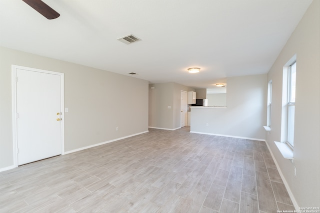 unfurnished living room featuring ceiling fan and light wood-type flooring