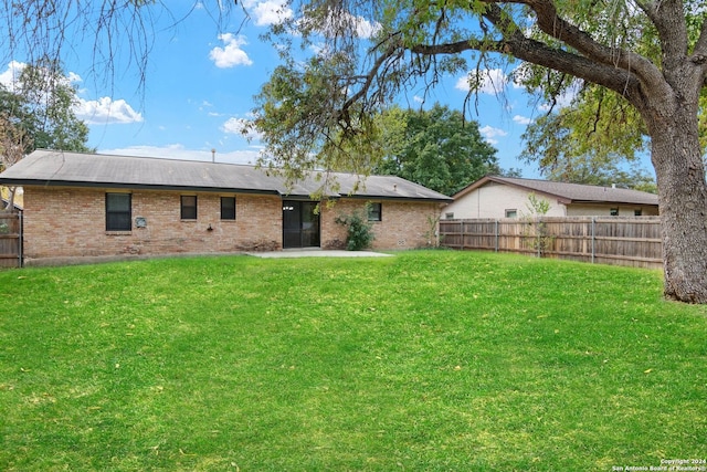 rear view of property with a lawn and a patio area