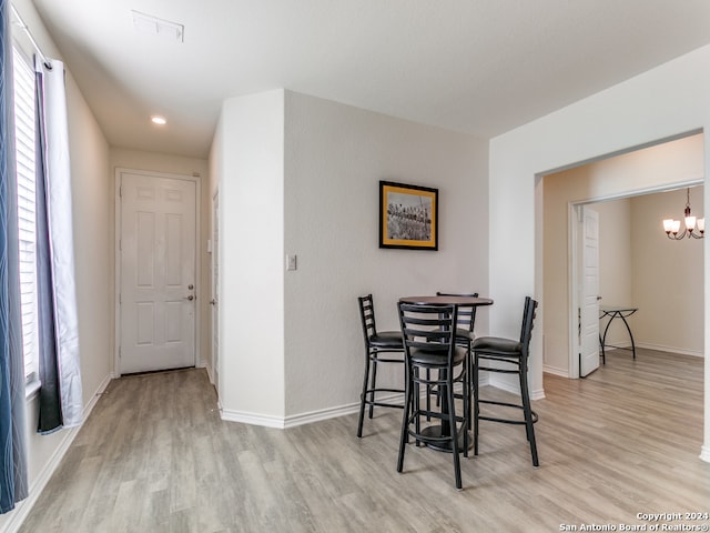 dining space featuring a notable chandelier and light wood-type flooring