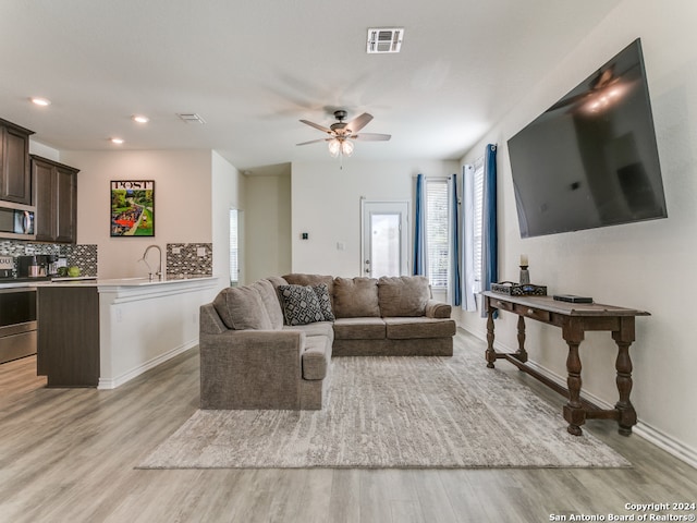 living room with ceiling fan and light wood-type flooring