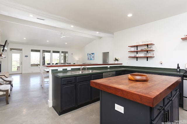 kitchen with ceiling fan, sink, lofted ceiling with beams, stainless steel dishwasher, and a kitchen island