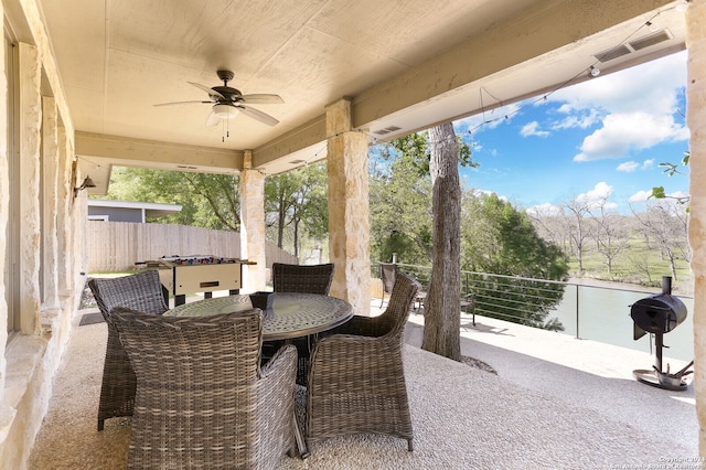 view of patio / terrace featuring ceiling fan and a water view