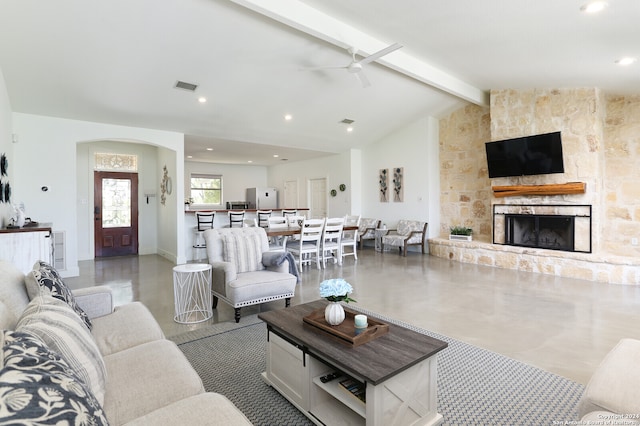 living room featuring vaulted ceiling with beams, ceiling fan, and a fireplace