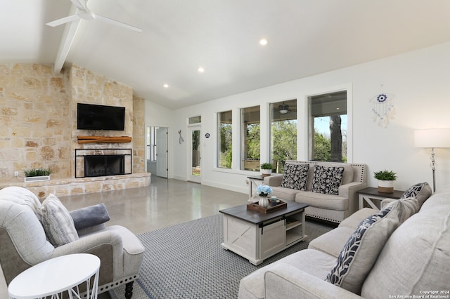 living room featuring vaulted ceiling with beams, ceiling fan, and a stone fireplace