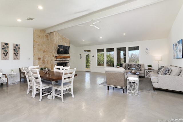 dining area featuring a fireplace, vaulted ceiling with beams, and ceiling fan