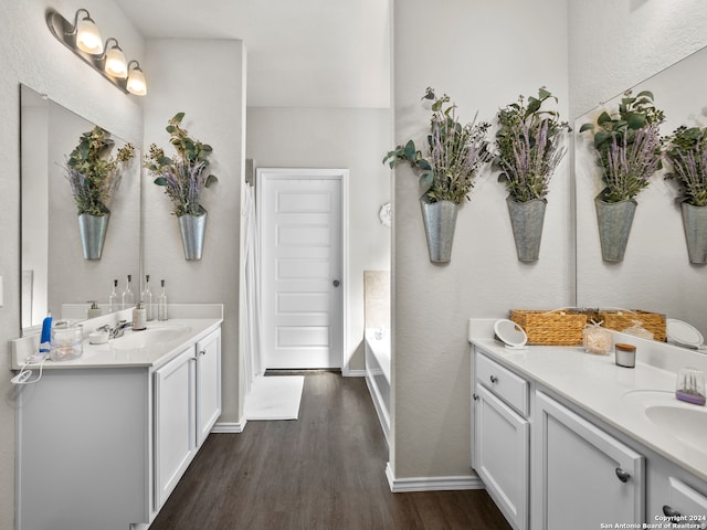 bathroom with a bathtub, vanity, and wood-type flooring