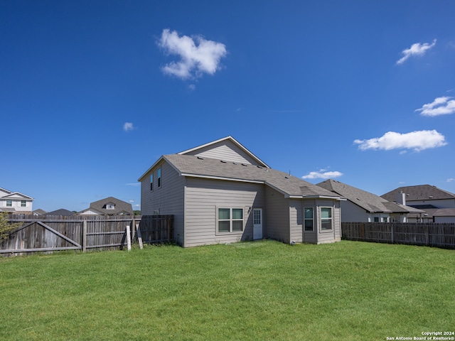 rear view of property featuring a yard