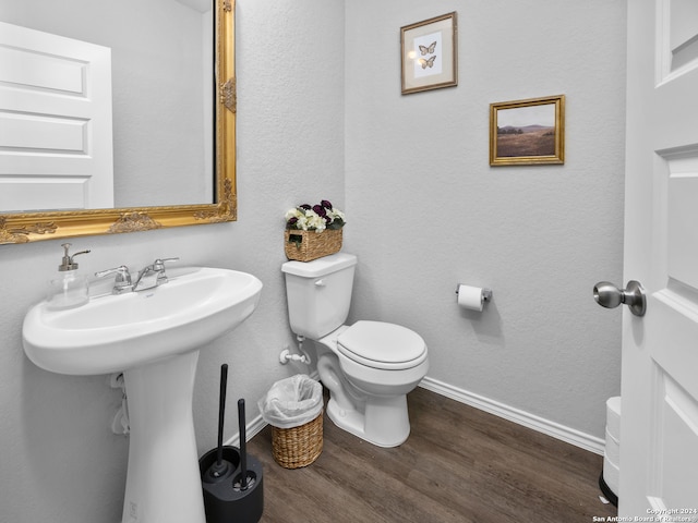 bathroom with toilet and hardwood / wood-style flooring