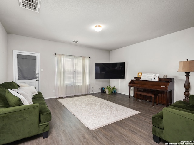 living room with dark wood-type flooring and a textured ceiling