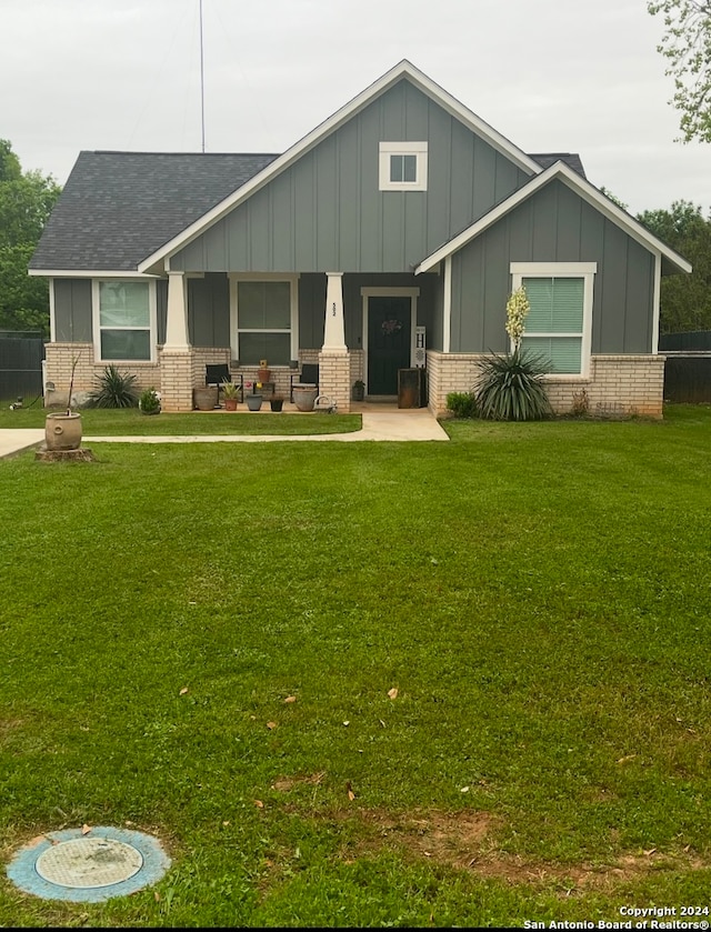 craftsman-style home with a front yard and covered porch