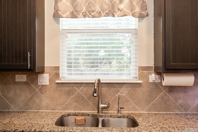 room details with light stone counters, sink, and dark brown cabinets