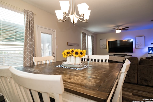 dining space featuring dark wood-type flooring and ceiling fan with notable chandelier