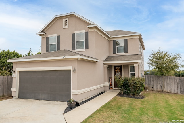 view of property featuring a garage and a front lawn