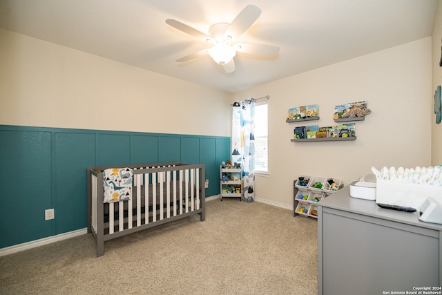 bedroom featuring ceiling fan, light carpet, and a nursery area