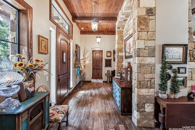 hallway with beamed ceiling, dark hardwood / wood-style floors, and wood ceiling