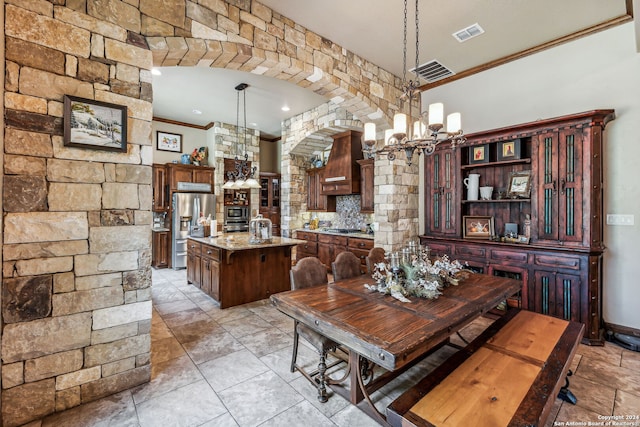 dining space featuring crown molding and a chandelier