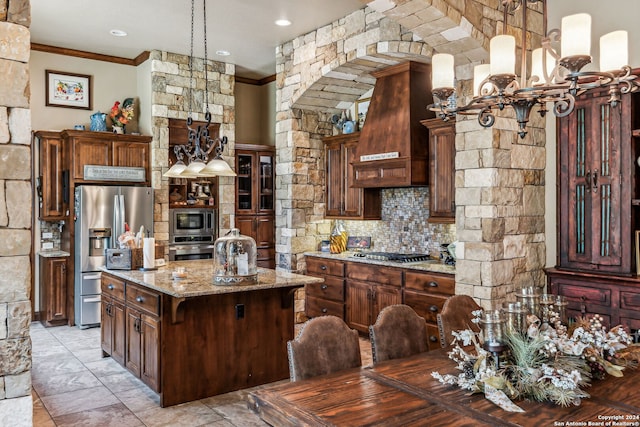 kitchen with light stone countertops, custom exhaust hood, a breakfast bar, stainless steel appliances, and a kitchen island with sink