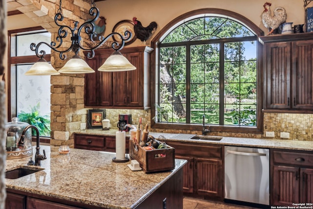 kitchen with dishwasher, decorative backsplash, light stone counters, and sink