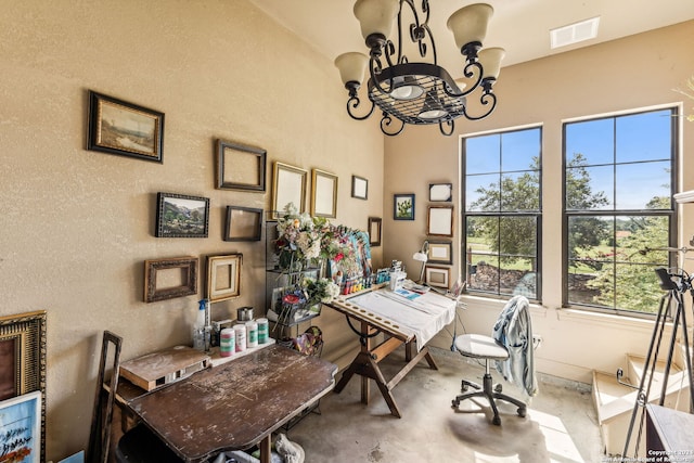 office area with plenty of natural light, concrete flooring, and a chandelier