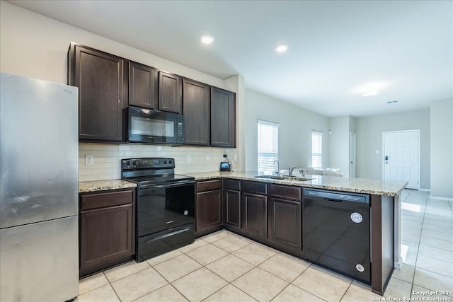 kitchen with black appliances, kitchen peninsula, sink, tasteful backsplash, and dark brown cabinetry