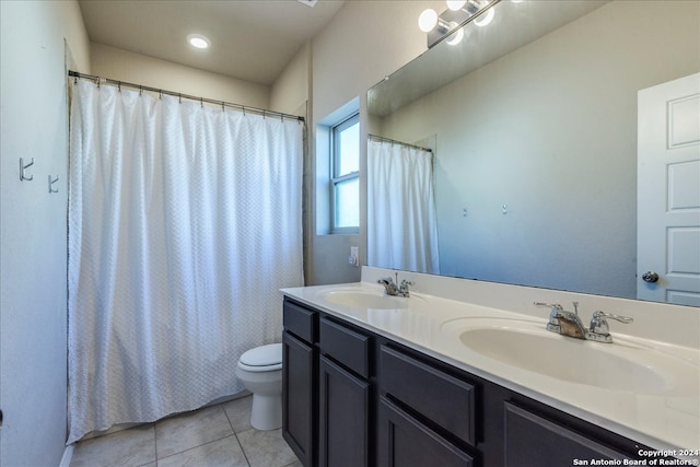 bathroom with tile patterned flooring, vanity, and toilet