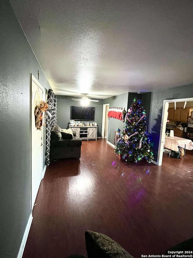 living room with wood-type flooring, a textured ceiling, and ceiling fan