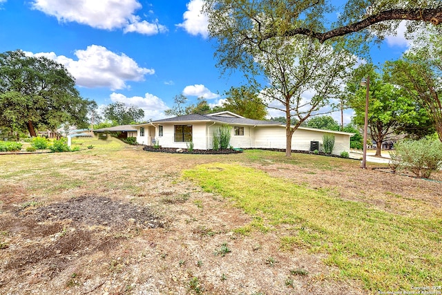 back of property with a yard and a carport