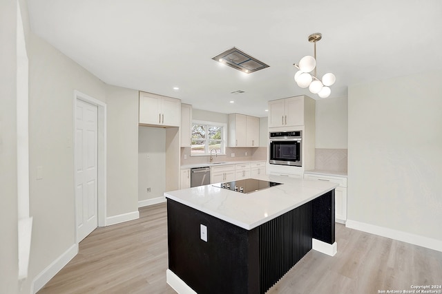 kitchen featuring appliances with stainless steel finishes, a center island, white cabinetry, and pendant lighting