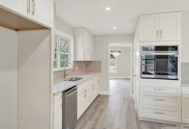 kitchen featuring sink, white cabinetry, stainless steel appliances, and light hardwood / wood-style flooring