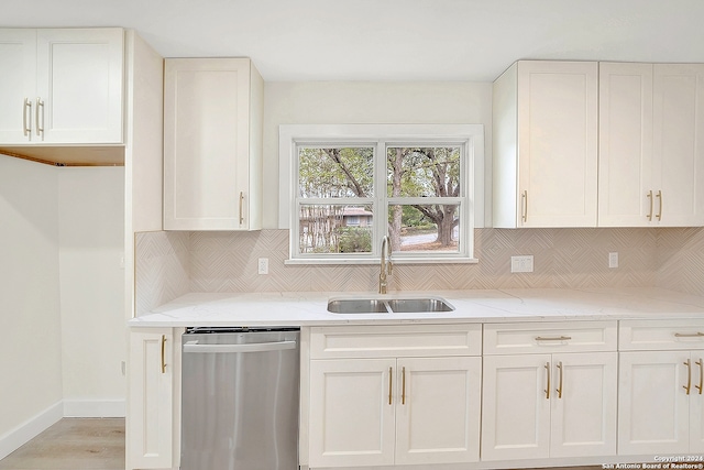 kitchen featuring dishwasher, white cabinets, and sink