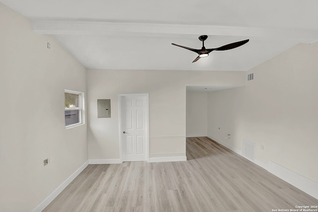 empty room featuring electric panel, ceiling fan, lofted ceiling with beams, and light wood-type flooring