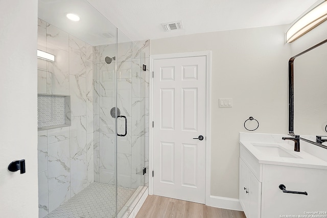 bathroom featuring vanity, hardwood / wood-style flooring, and walk in shower