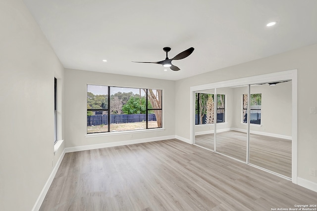 unfurnished bedroom featuring light hardwood / wood-style flooring, a closet, and ceiling fan