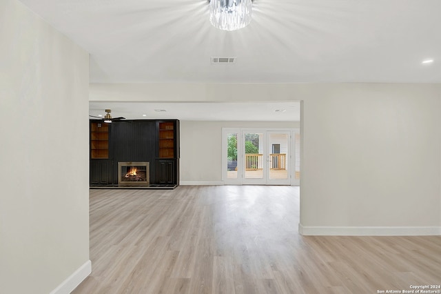 unfurnished living room featuring a fireplace, light hardwood / wood-style flooring, and ceiling fan