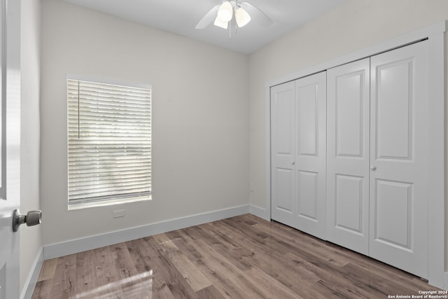 unfurnished bedroom featuring a closet, light hardwood / wood-style floors, and ceiling fan