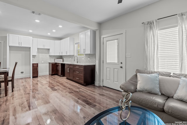 living room featuring sink and light hardwood / wood-style floors