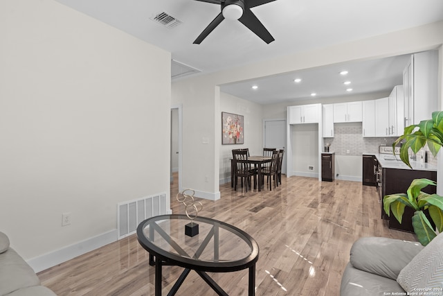 living room featuring ceiling fan and light hardwood / wood-style floors